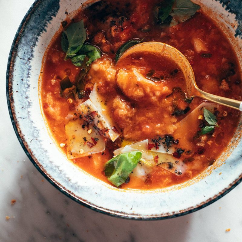 Spoon in bowl of tomato and bread soup