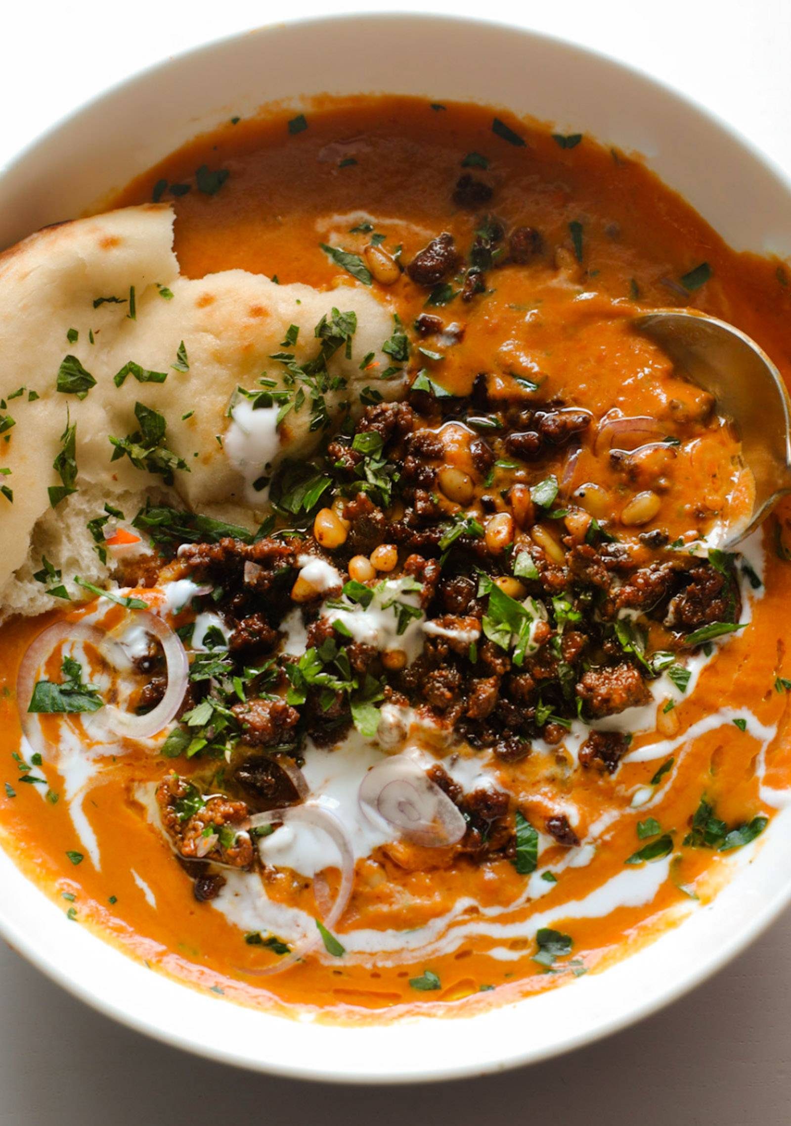 Carrot soup with spiced ground beef on top.