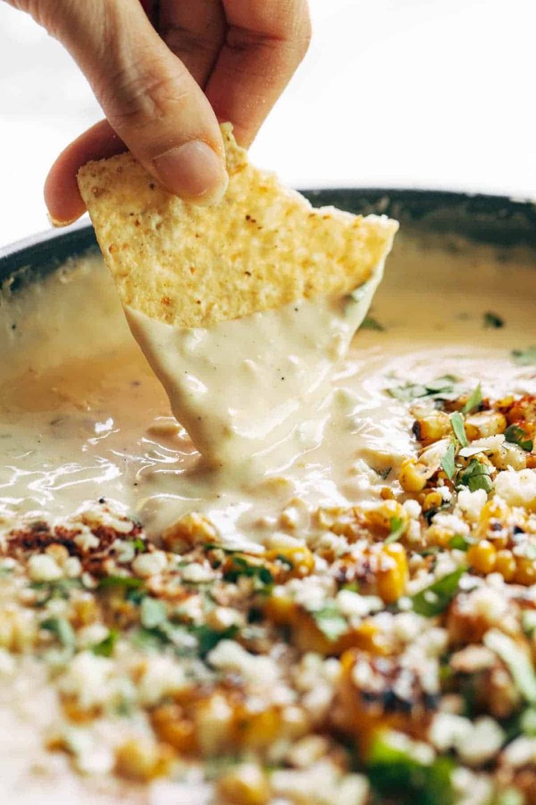 Dipping a chip into elote queso.