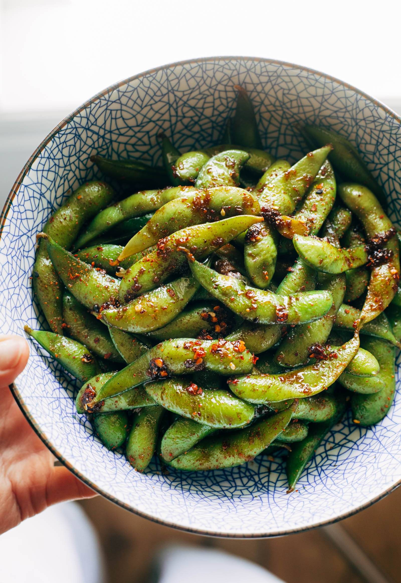 Garlic edamame coated with chili crisp in a bowl