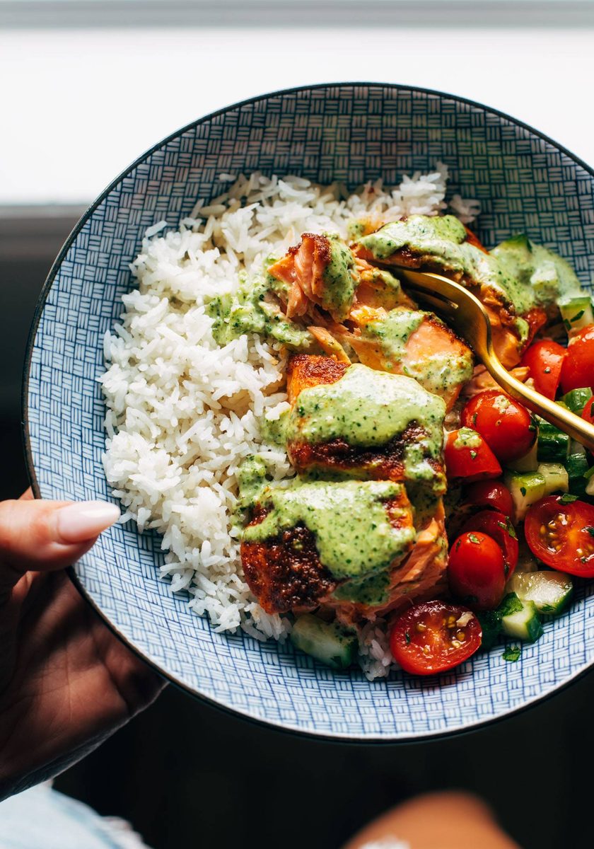 Salmon with basil sauce, tomato salad, and rice in a bowl