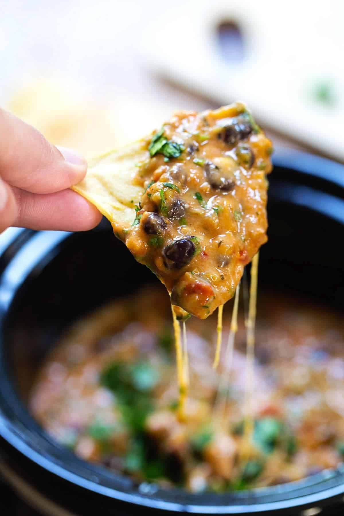 Dipping a chip in cheesy chili dip.