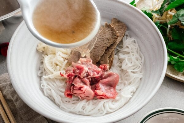ladling pho soup over steak | www.iamafoodblog.com