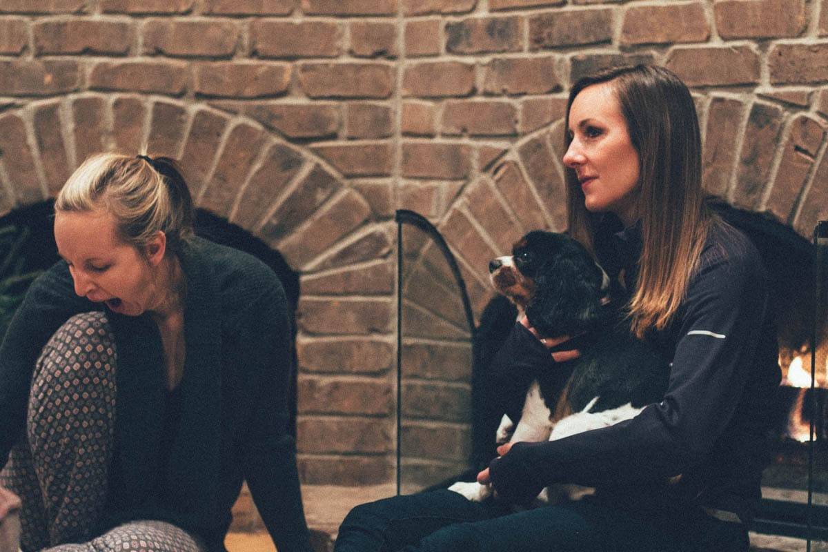 People sitting by a fireplace.