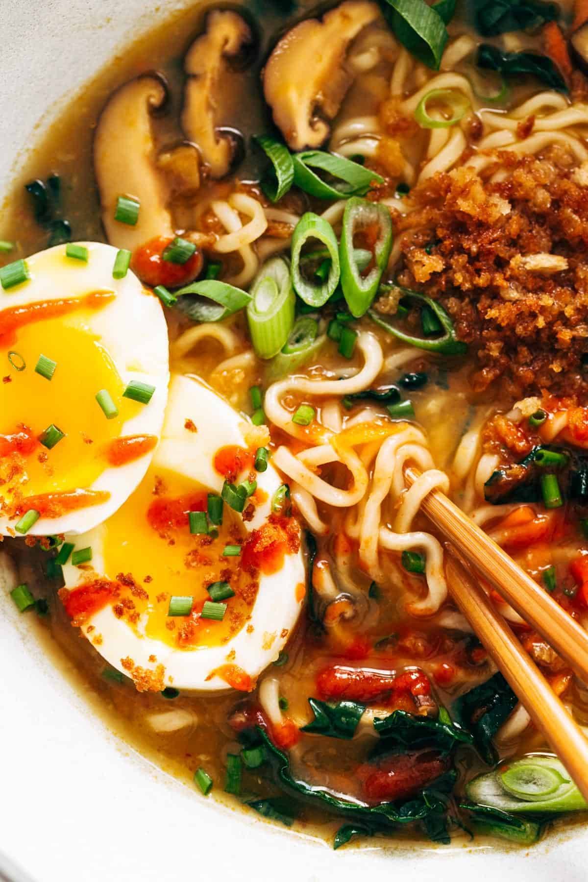 Quick Homemade Ramen - comes to life with fresh vegetables and herbs in just in 20 minutes! | pinchofyum.com Close-up image of Quick Homemade Ramen with chopsticks and a soft egg.