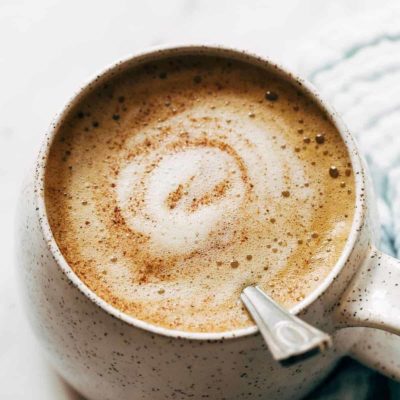 Honey oatmilk latte with a spoon in it.