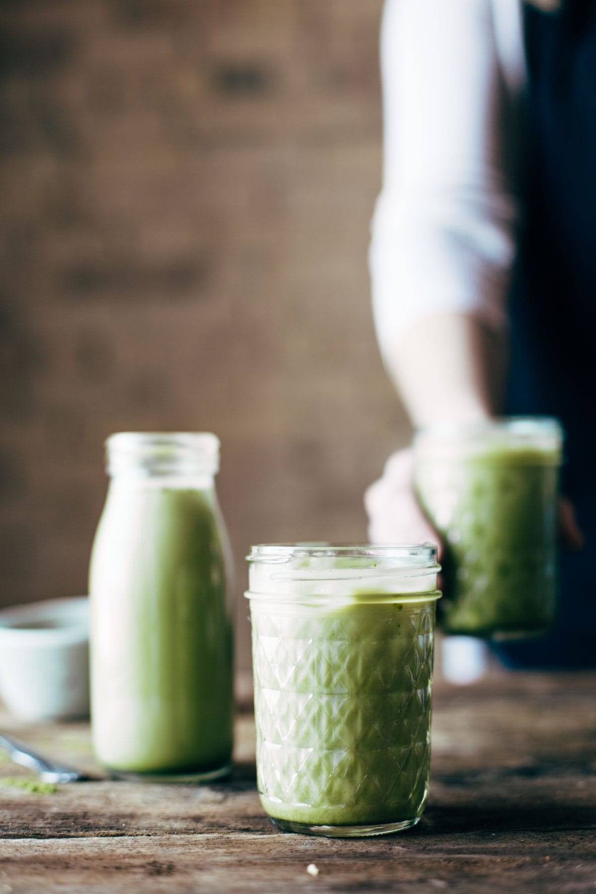 Mason jars filled with iced matcha green tea latte. 