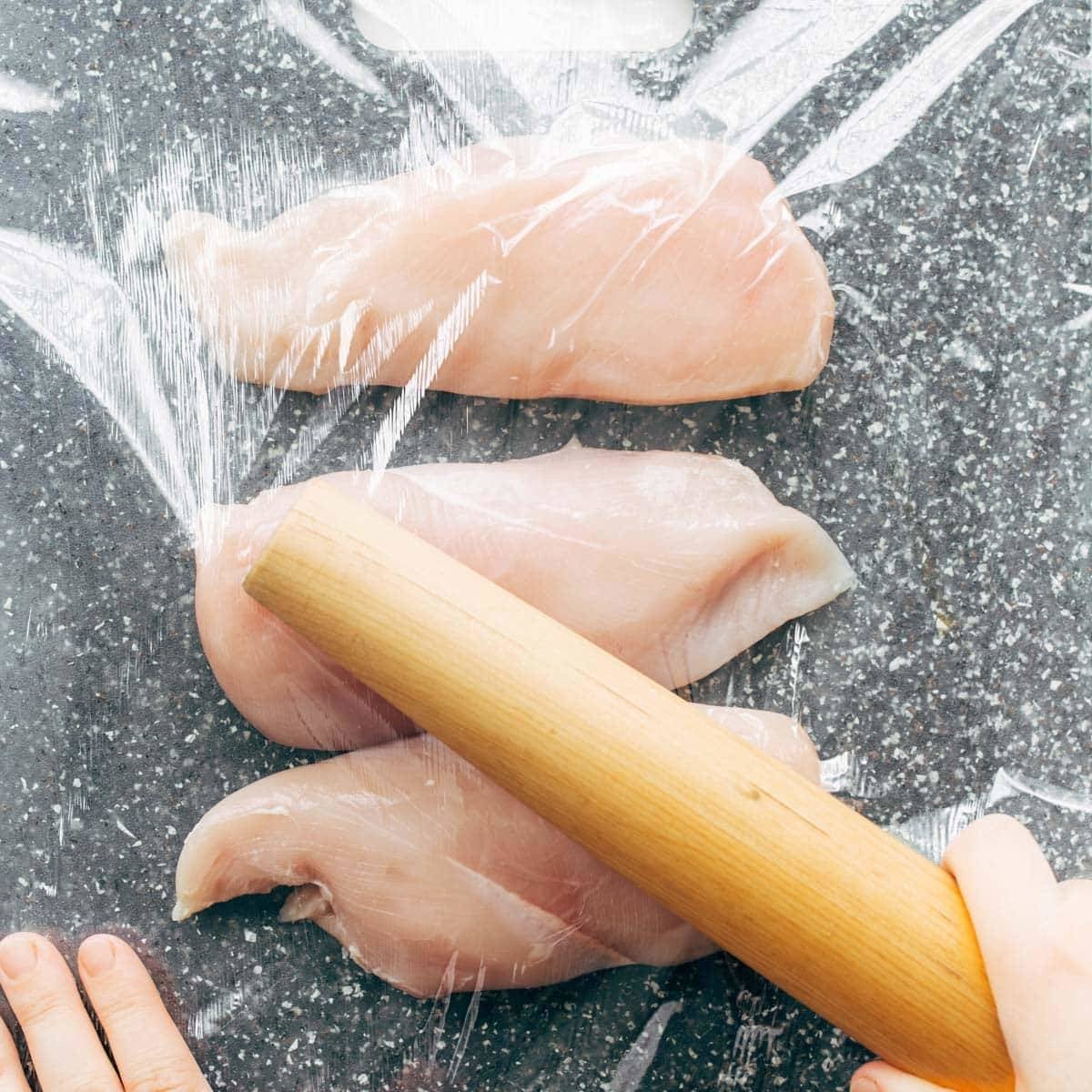 Pounding chicken breasts.