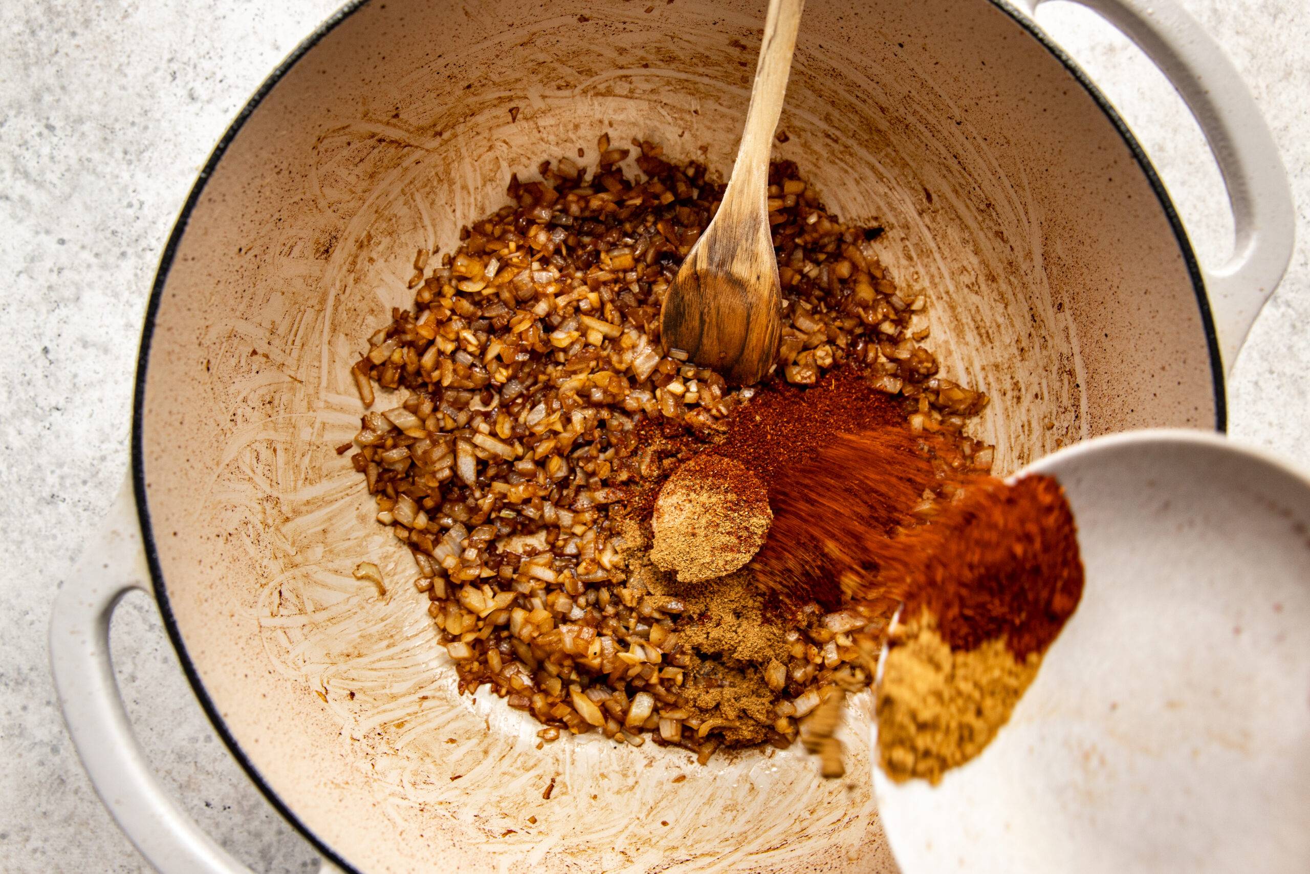 Adding spices to garlic and onion.